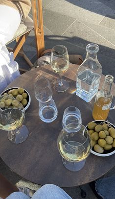 some olives are sitting on a table with wine glasses