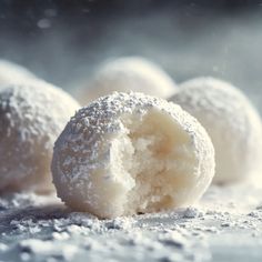 powdered sugar covered doughnuts sit on a table