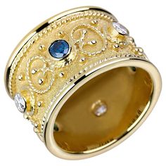 a gold ring with blue and white stones on the inside, set in 18k yellow gold