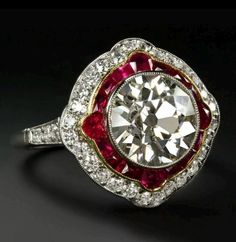 The solid 14K white gold setting is designed to capture the essence of antique elegance, perfectly showcasing the 3 carat round cut moissanite center stone with exceptional brilliance. Vibrant rubies accent the moissanite, creating a striking blend of color and light. Inspired by the timeless beauty of vintage jewelry, this ring exudes both sophistication and boldness. The moissanite offers a radiant, eco-friendly alternative to diamonds, while the rubies bring an added touch of classic luxury. European Cut Diamonds, Filigree Ring, Antique Diamond, Vintage Jewels, Bezel Diamond, Ruby Ring, Vintage Diamond, Statement Ring, Ring Set