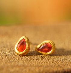 24k gold jewelry//red sapphire studs//24k gold Studs//24k gold earrings//red sapphire earrings//drop gold earrings//solid gold studs These studs earrings are full of life and sparkle and would be amazing for a wedding, a special occasion or for every day wear. The red sapphire is:  approximately 3X5.5  mm . with the gold bezel setting it is approximately 5x7 mm all hand made with 24k gold.  this is a one of a kind item.  post are made from 20k yellow gold  14k gold  ear nut /backs Those earrings Red 22k Gold Earrings For Gift, Sapphire Earrings Drop, Red Sapphire, Sapphire Studs, Sapphire Earrings, Gold Studs, Jewelry Earrings Studs, Solid Gold, Gold Earrings