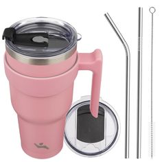 a pink coffee cup next to two straws and a glass with a straw in it