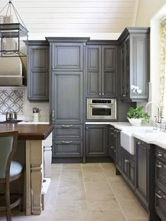 a kitchen with gray cabinets and white counter tops