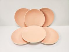 five pink plates stacked on top of each other