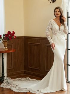 a woman in a white wedding dress posing for the camera