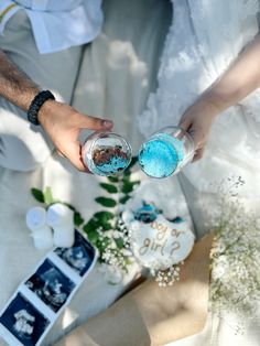 two people are holding blue and white cake