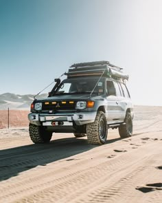 an suv driving through the desert on a sunny day