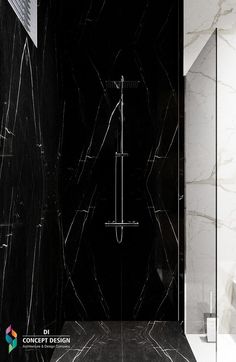 a black and white bathroom with a shower head in the corner, marble walls and floor