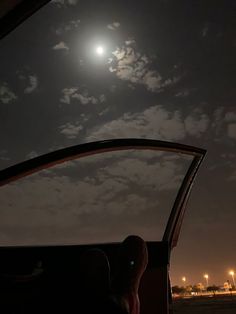 the full moon is shining brightly in the night sky as seen from inside a vehicle