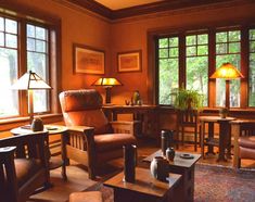 a living room filled with furniture and lots of windows next to a table topped with two lamps