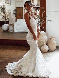 a woman in a white wedding dress posing for the camera with her hand on her hip