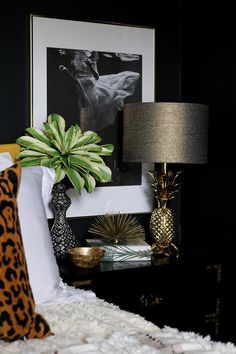 a bedroom with black walls and white bedding has a leopard print pillow on it