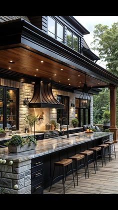 an outdoor kitchen and dining area with wood flooring, stone counter tops and black appliances