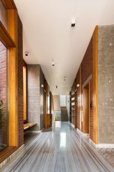 an empty hallway with wooden doors and brick walls on both sides, leading to the second floor