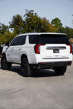 the rear end of a white suv parked in a parking lot