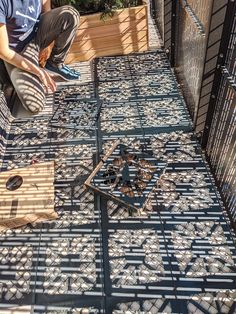 a man kneeling down on top of a metal grate