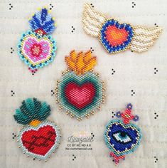 cross stitched hearts and angel wings on a white tablecloth with beadwork