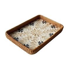 a wicker tray with black and white designs on the bottom is shown in front of a white background