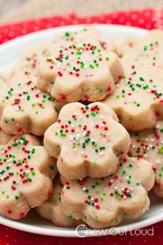 a plate full of sugar cookies with sprinkles on it and a red napkin