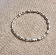 Sterling silver beaded stretch bracelet 7mm oval beads and 3mm beads. This bracelet is made with 7mm oval beads spaced with 3mm sterling silver beads restrung onto quality beading elastic.  A simple but stunning bracelet which can be worn on its own or stacked with other bracelets. This bracelet is available in different lengths please choose your size from the drop down list. This bracelet is available in different sizes and will be made to order especially for you, with the choice of arriving in an organza bag or goft box and velvet pouch. Simple Silver Bracelet, King's Lynn, Bracelet Simple, Oval Beads, Star Bracelet, Velvet Pouch, Beaded Stretch Bracelet, Sterling Silver Bead, Organza Bags