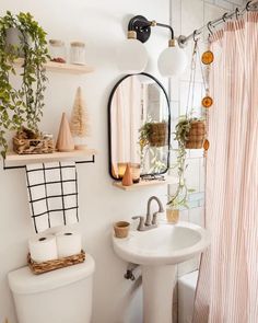 a bathroom with a toilet, sink and shower curtain in it's window sill