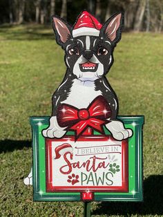 a sign with a dog wearing a santa hat and bow on it's head