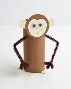 a monkey made out of toilet paper on top of a white surface with eyes and hands