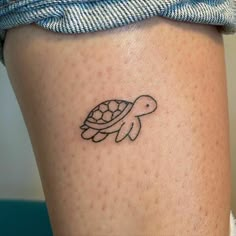 a small turtle tattoo on the thigh