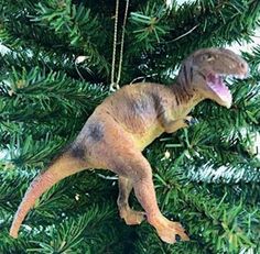 a dinosaur ornament hanging from a christmas tree