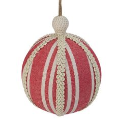 a red and white striped ball ornament hanging from a string on a white background