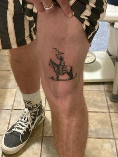 a man with a cowboy tattoo on his leg