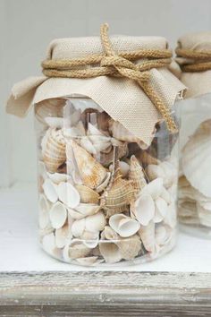 a jar filled with seashells sitting on top of a table