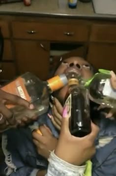 a group of people drinking from bottles in a kitchen