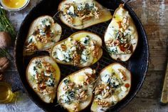 baked potatoes with spinach and walnuts in a skillet on a wooden table