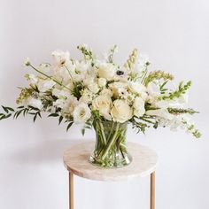 a vase filled with white flowers on top of a table