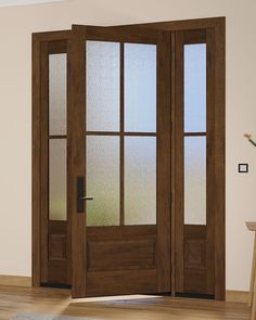 a wooden door with frosted glass on the front and side doors in an empty room