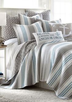 a bed with blue and white striped comforters