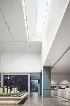 an empty room with concrete flooring and white walls is lit by recessed lights