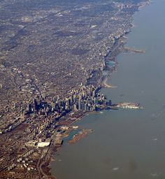 an aerial view of a large city and the water in front of it is shown