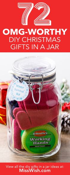 a glass jar filled with christmas gifts on top of a wooden table