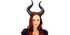 a woman with horns on her head is posing for the camera