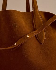 The Eleanor Tote is the perfect slouchy, easy tote bag. Crafted from the softest Calfskin suede in Honey with tonal stitching, the Eleanor Tote features a third strap which fastens using our signature collar studs. Easy Tote Bag, Amanda Jones, Slouchy Tote, Suede Tote Bag, Travel Scarf, Suede Bag, Pocket Books, Olympia Le Tan, Mark Cross