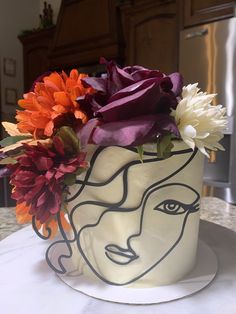 there is a cake with flowers in the shape of a woman's face on it