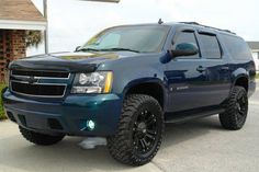 a blue suv parked in front of a house