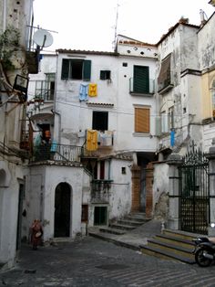 a motorcycle parked in front of an old building with stairs and balconies on the side