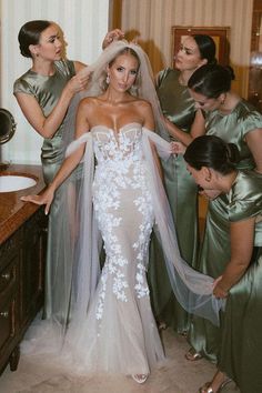 bridesmaids helping the bride put on her veil in preparation for her big day