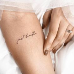 a woman's arm with the word just breathe tattooed on it, in black ink