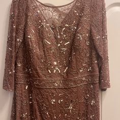 a dress hanging on the wall in front of a door with an open top and sequins