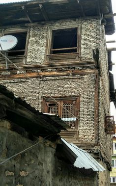 an old brick building with a satellite dish on the roof