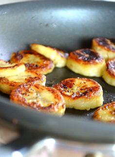 bananas frying in a pan on top of a stove with other food items cooking